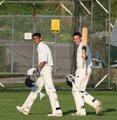 A smiling Kamran Anwar and Adrew Cook return to the pavillion after their match winning stand